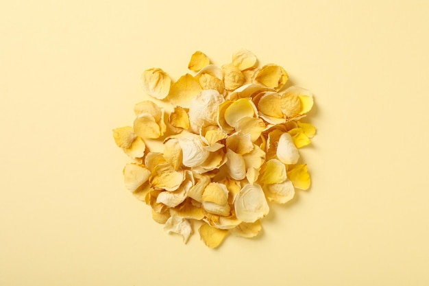 Free photo dried yellow petals on beige background top view