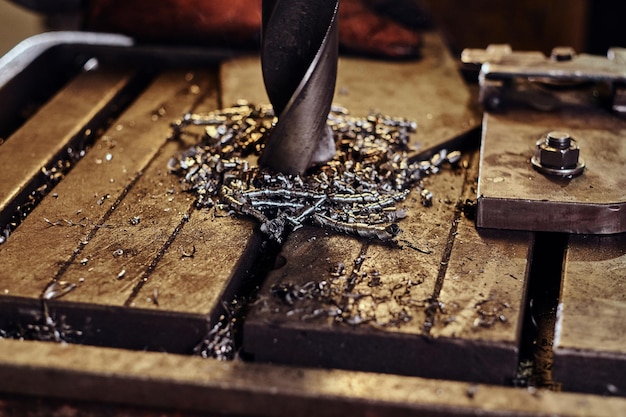 Free photo drilling hole in the metal with giant drill at steel factory by worker male.