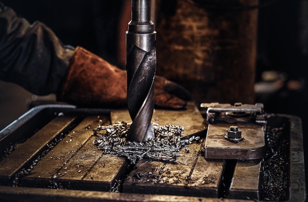 Free Photo drilling hole in the metal with giant drill at steel factory by worker male.