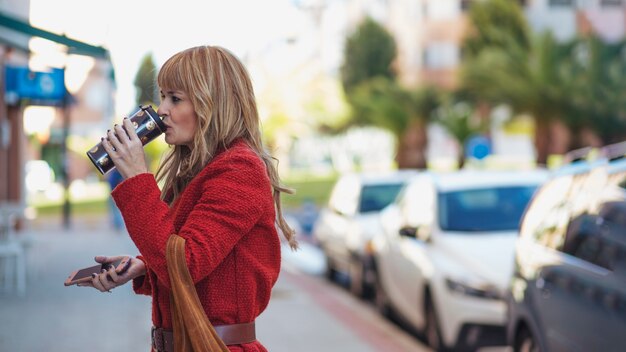 Drinking woman with smartphone