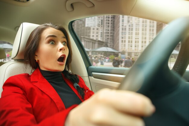 Driving around city. Young attractive woman driving a car