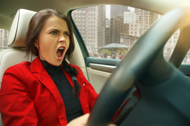 Free photo driving around city. young attractive woman driving a car