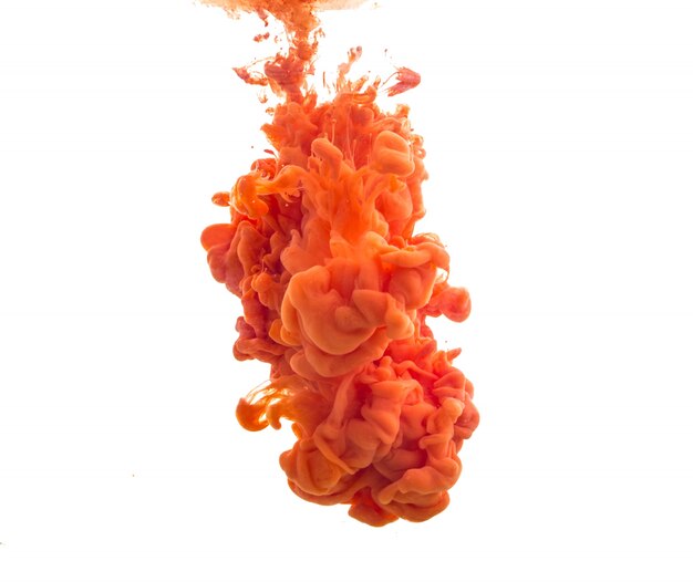 Drop of orange paint falling in water