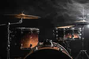 Free photo drum kit on a dark background with stage lighting, copy space.