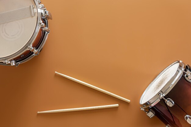 Drums and drum sticks on a brown background top view