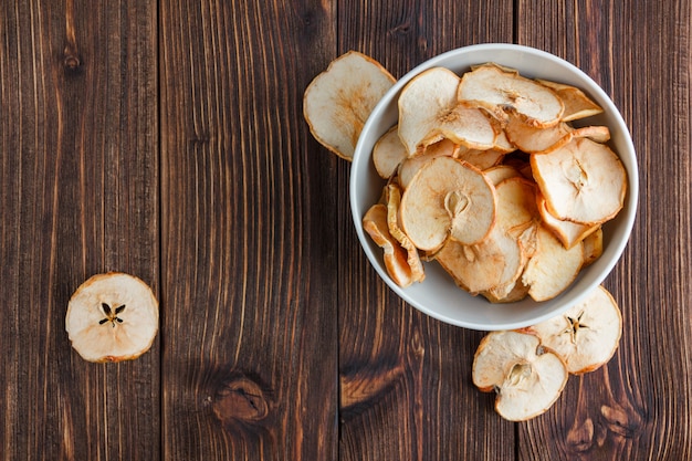 Dry apple in a bowl on a wooden background. top view. space for text