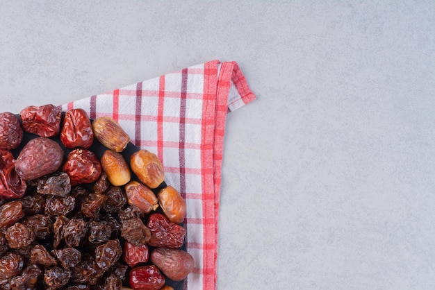 Dry fruit combination on a platter on concrete background.