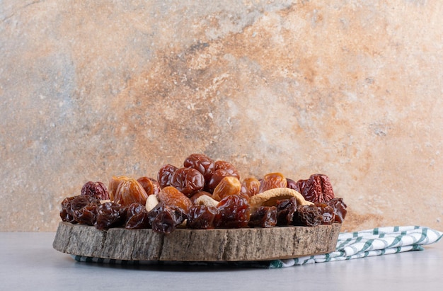 Dry fruit combination on a platter on concrete background.