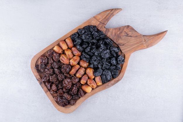 Dry fruits set with dates and cherries on a wooden platter. High quality photo