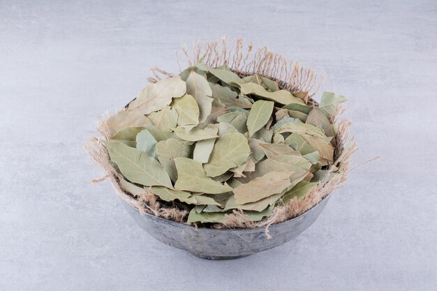 Dry green bay leaves in a rustic cup. High quality photo