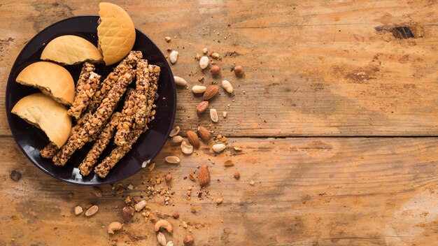 Dryfruits; cookies and granola bar on wooden textured background