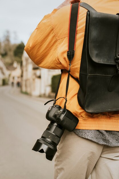 DSLR camera with strap hanging on photographer's shoulder