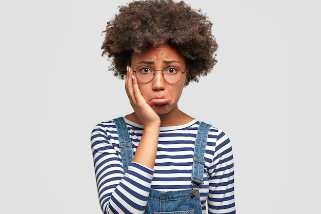 Dull doleful young African American female has sorrowful expression