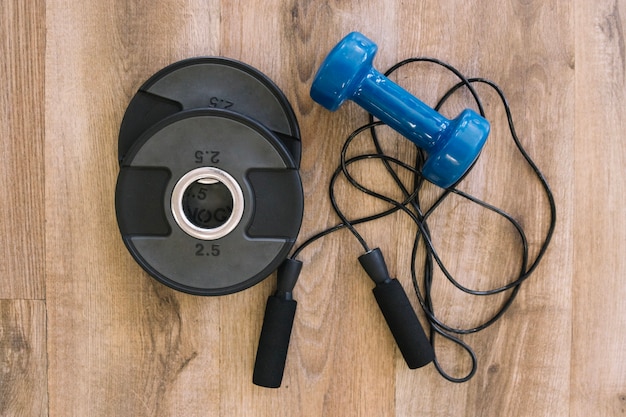 Free photo dumbbell, jump rope and weights for barbell