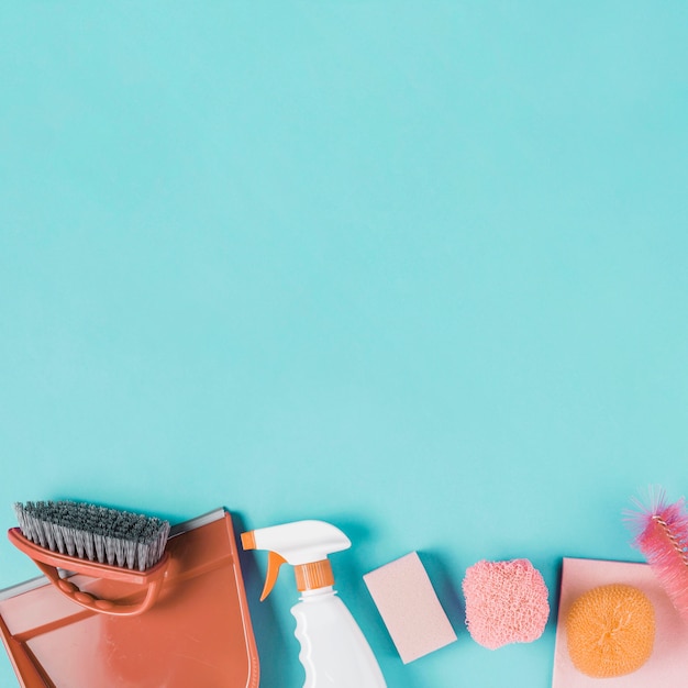 Free Photo dustpan, spray bottle and scrub on turquoise background