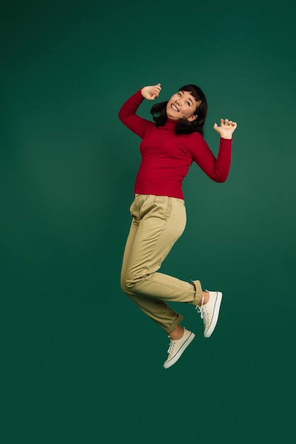 East asian woman's portrait isolated on green studio background with copyspace