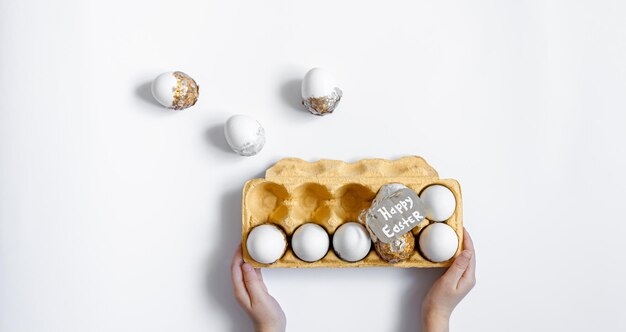 Easter background with decorative eggs tray isolated on white flat lay