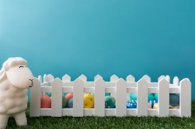 Free photo easter background with sheep next to a wooden fence