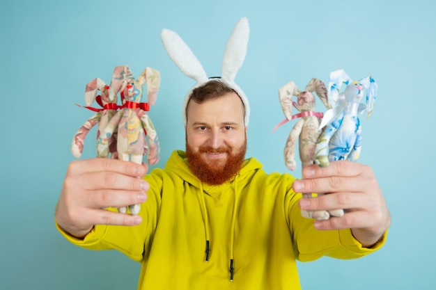 Free Photo easter bunny man with bright emotions on blue wall