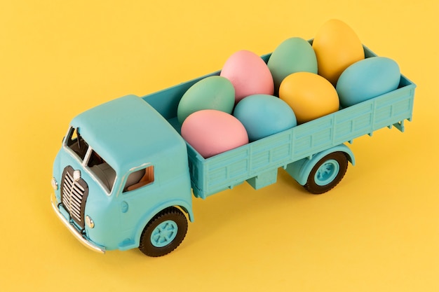 Free Photo easter car with eggs and yellow background