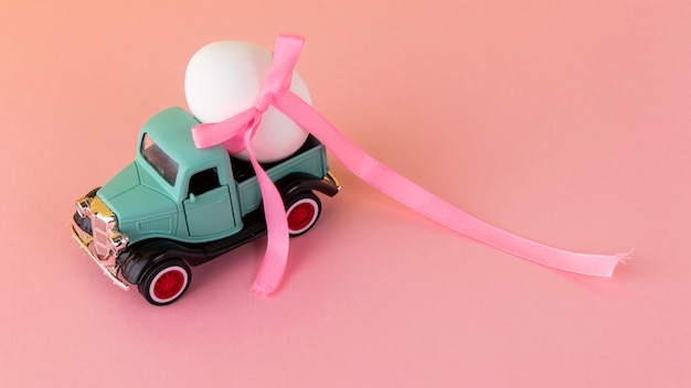 Free Photo easter car with white egg and pink ribbon high angle