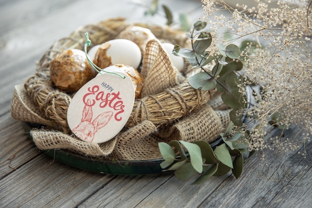 Free photo easter composition with decorated easter eggs and decorative nest on a wooden surface