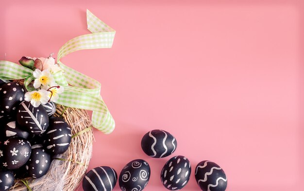 Easter composition with eggs on a pink table