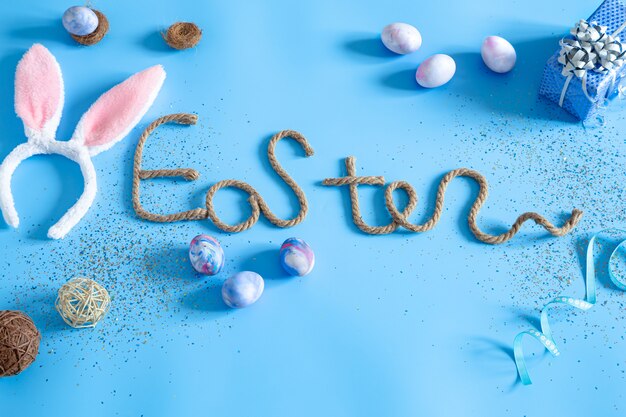 Easter creative inscription on blue with items of Easter decor.