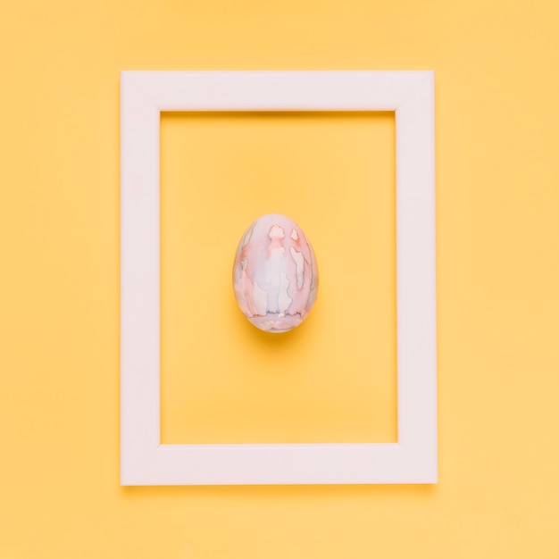 Free photo easter egg on white border frame against yellow background