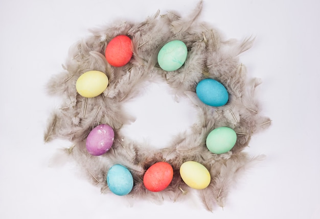 Free photo easter eggs in feather nest on table