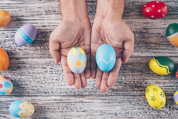 Free photo easter eggs in man_s hands and on wooden background.