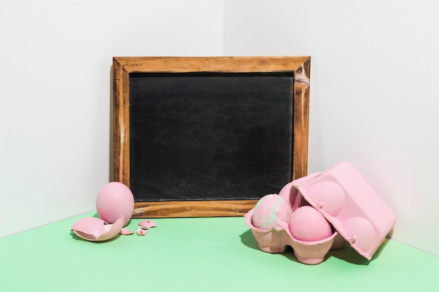 Easter eggs in rack with chalkboard on table