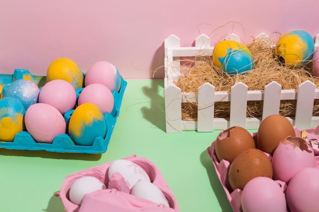 Easter eggs in racks and on hay on table