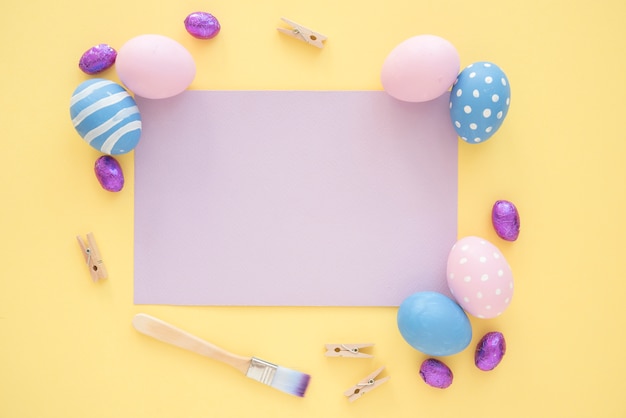 Easter eggs with blank purple paper on yellow table