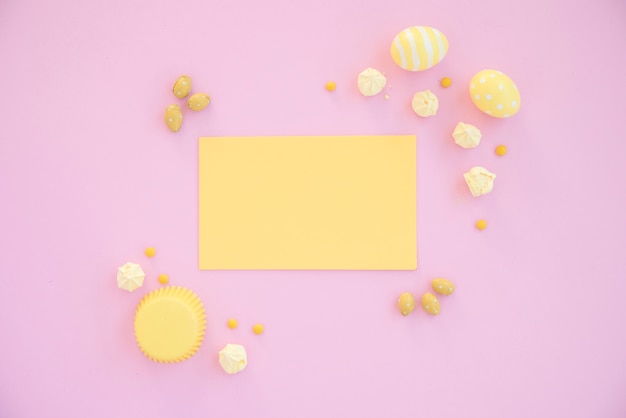 Easter eggs with blank yellow paper on table