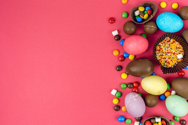 Easter eggs with chocolate eggs and candies on table