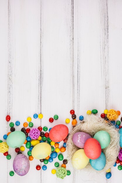 Easter eggs with small candies on table