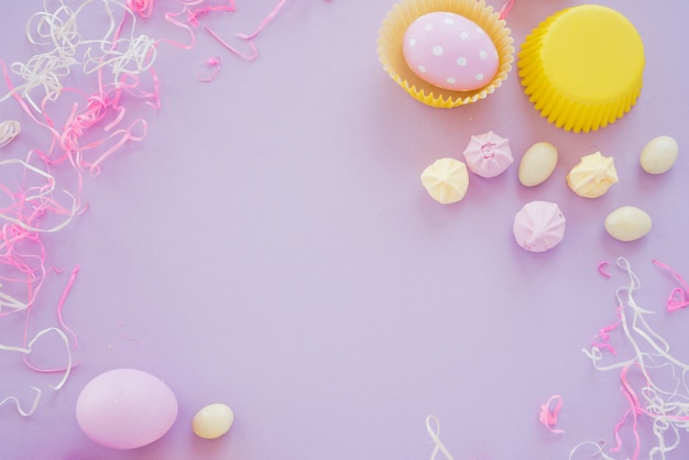 Easter eggs with small sweets on purple table