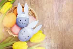 Free photo easter eggs and yellow tulips on wooden background