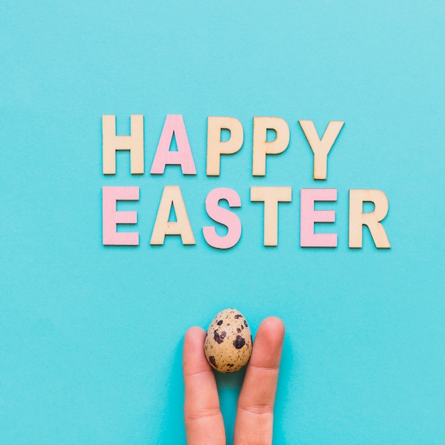 Free photo easter greeting and fingers with egg