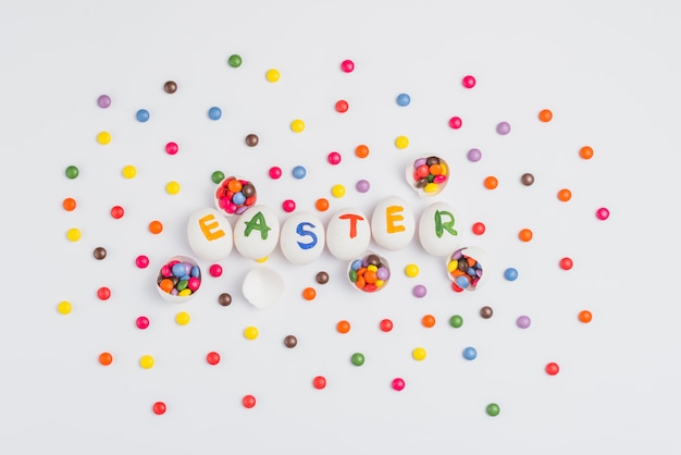 Easter inscription on eggs with candies on light table