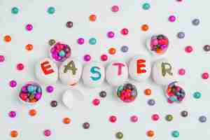 Free photo easter inscription on eggs with candies on table