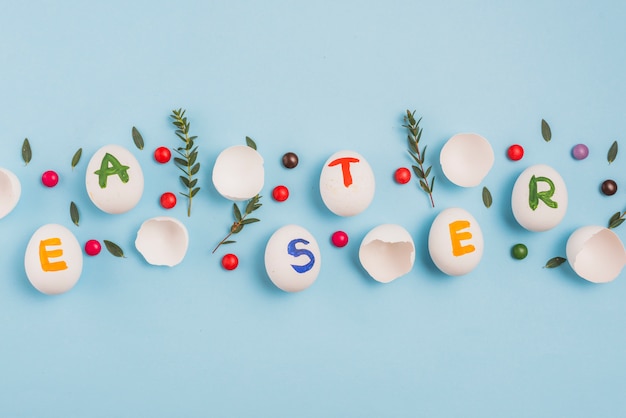 Easter inscription on eggs with plant branches on table