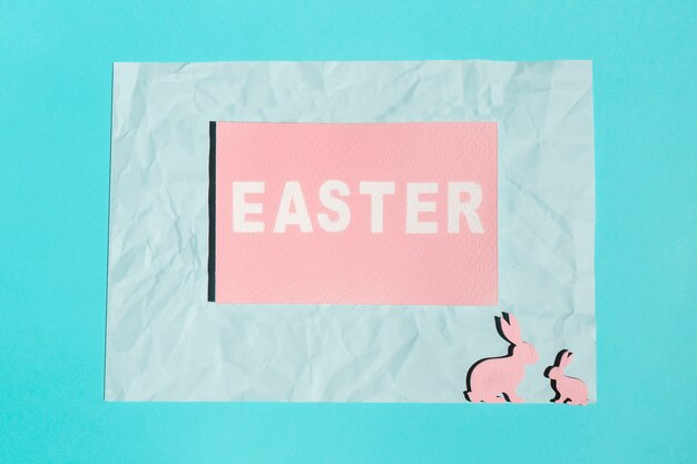 Easter inscription on paper with wooden rabbits 