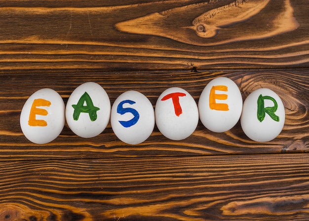 Free photo easter inscription on white eggs on table