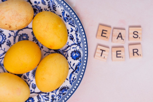 Easter inscription with colorful eggs on plate