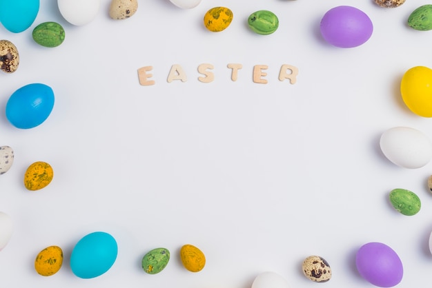 Easter inscription with colorful eggs on table