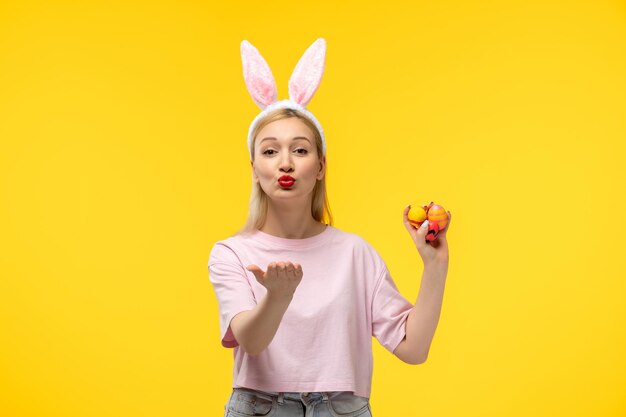 Easter lovely blonde adorable girl with pink bunny ears and red lipstick sending kisses