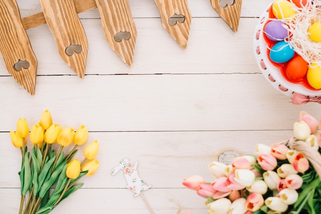 Easter prop; tulips; easter eggs; tulips and fence on wooden desk