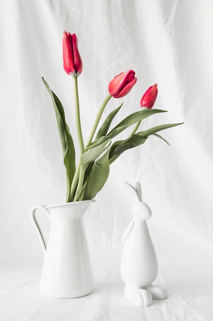 Free Photo easter rabbit near bunch of flowers in vase